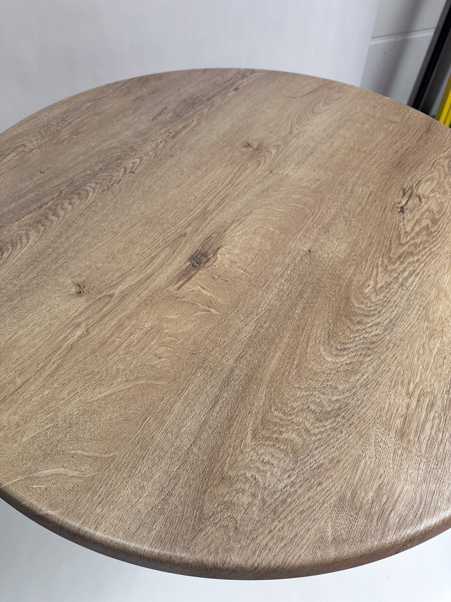 Detailaufnahme der runden Tischplatte Wahed Elm mit natürlicher Holzoptik, markanter Maserung und sanft abgerundeter Tischkante.