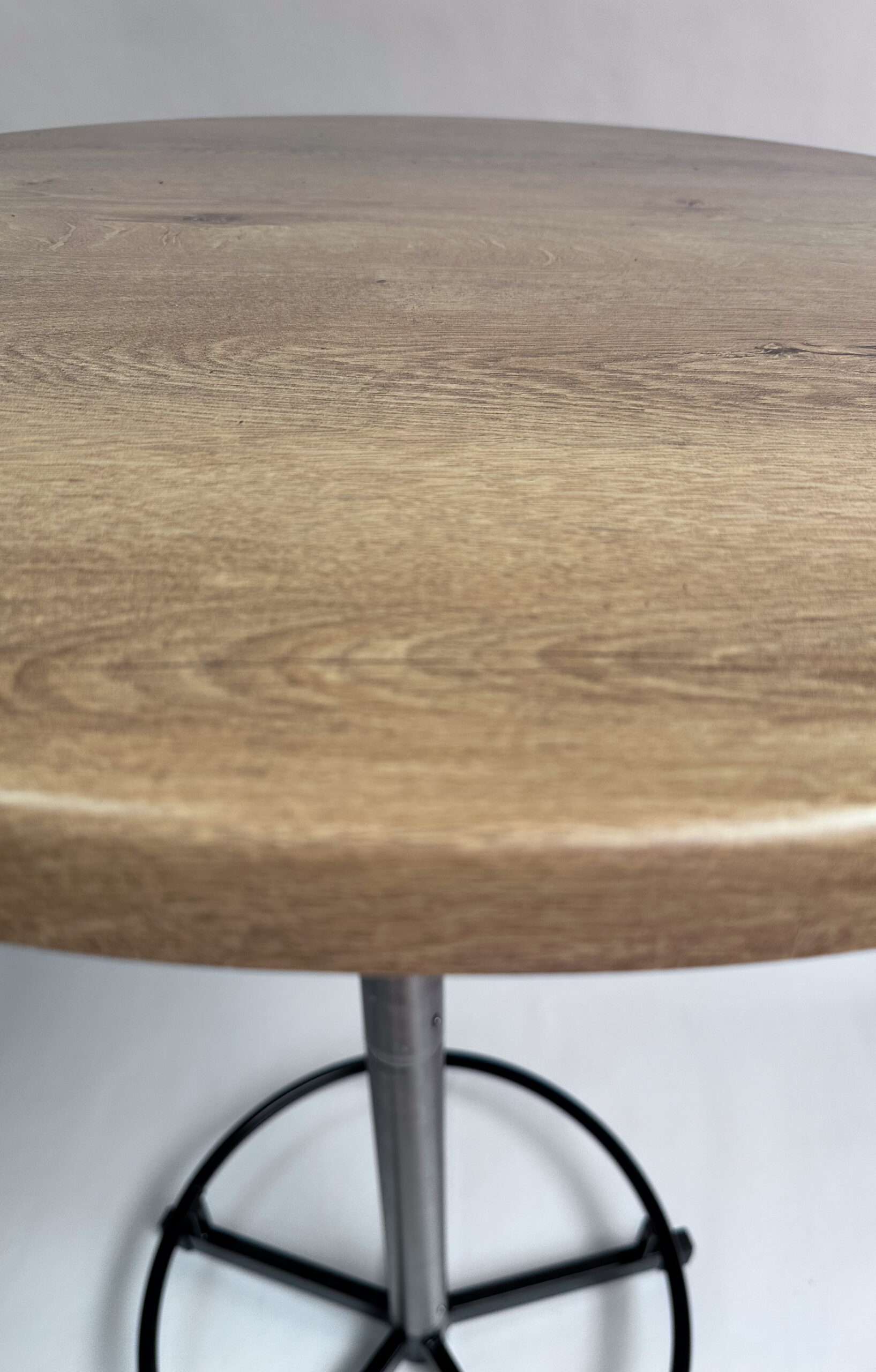 Nahaufnahme der Tischplatte Wahed Elm mit natürlicher Holzmaserung und sanft abgerundeter Tischkante.