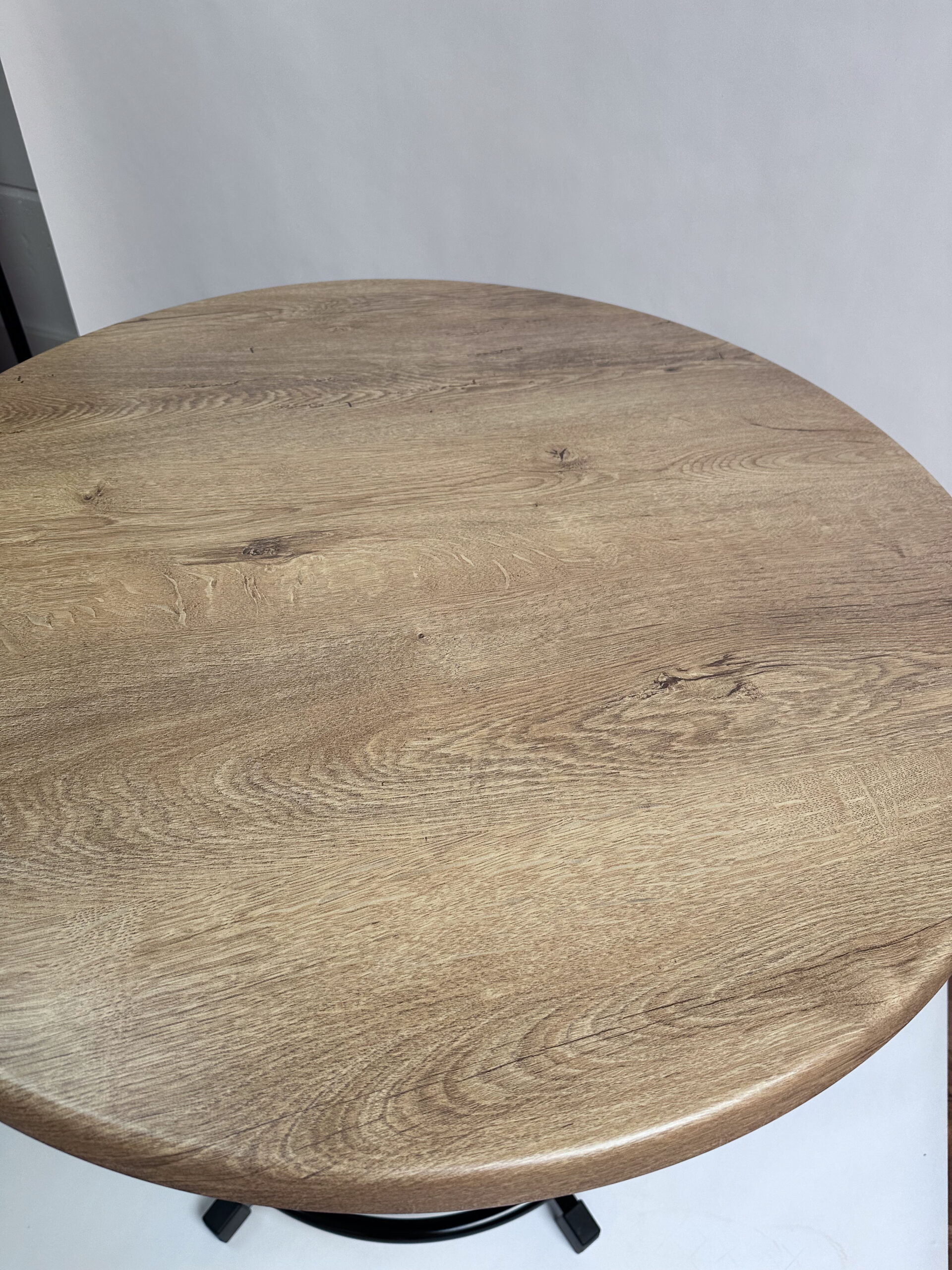 Runde Tischplatte Wahed Elm in warmer Holzoptik mit ausdrucksstarker Maserung, natürlichen Astzeichnungen und abgerundeter Kante.