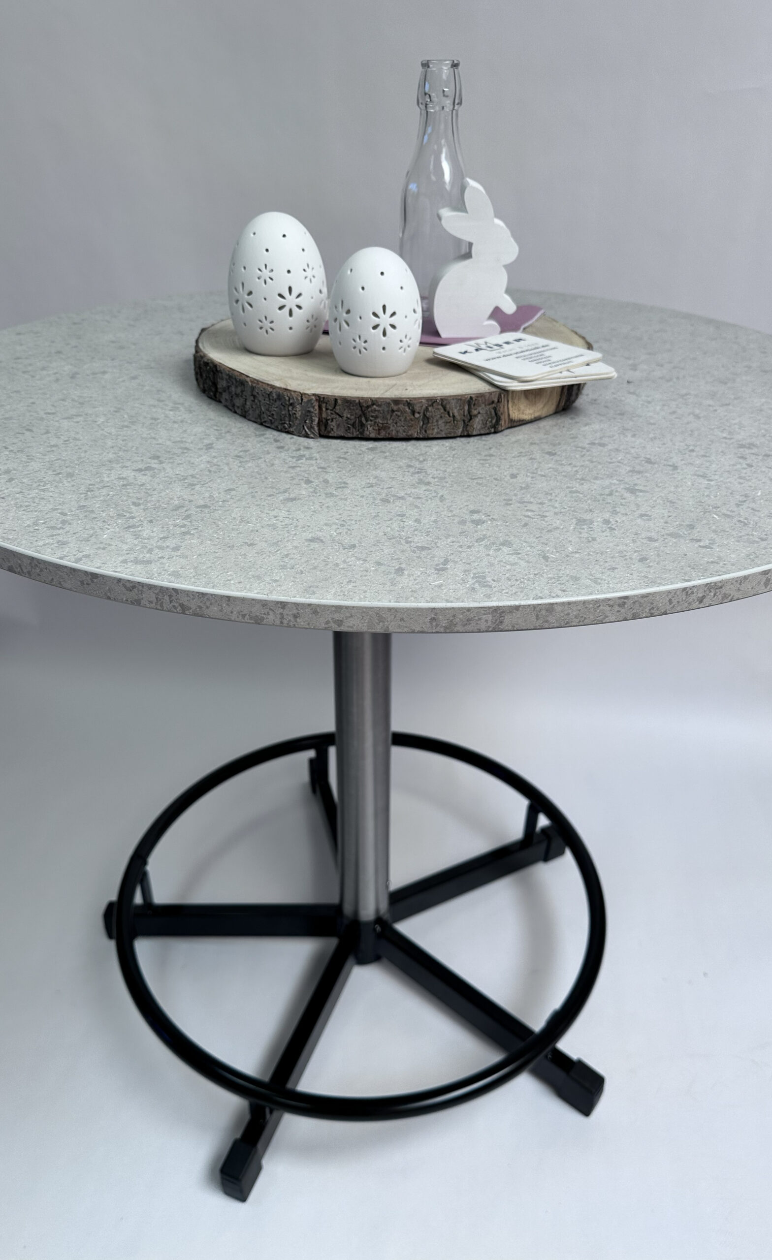 Praktisch Stehtisch - Marmor Granit mit heller runder Tischplatte, schwarzem Fußring und Dekoration